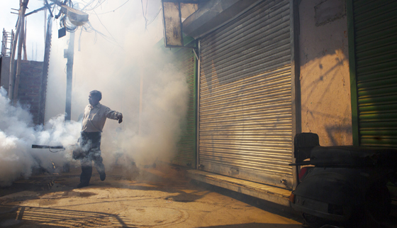 man fumigates an alley to prevent mosquito borne illnesses