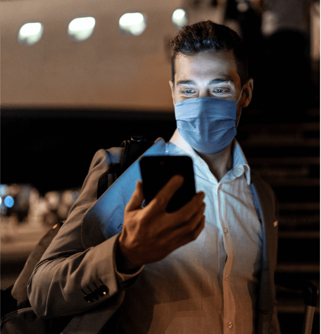 traveler with mask checking phone
