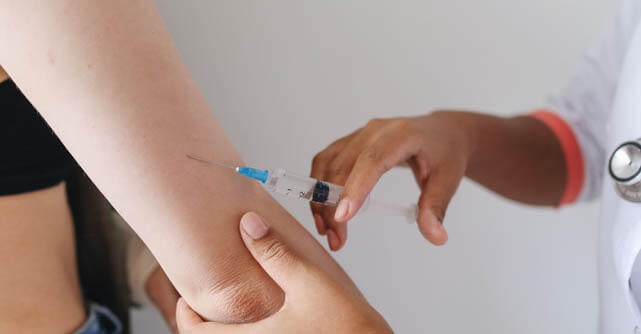 Healthcare provider administering an injection into a patient's arm