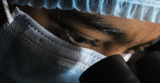 Close-up of a masked healthcare worker's eyes looking downward
