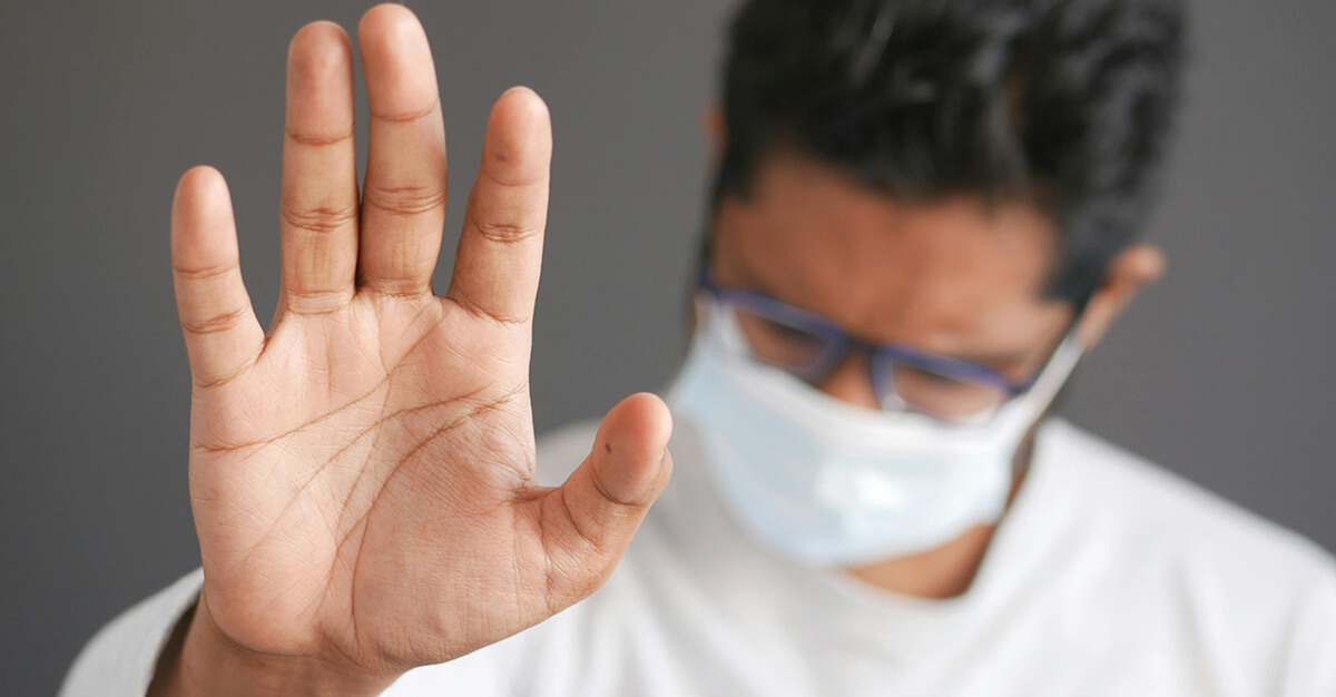 Man in Face Mask Doing Stop Sign Signal